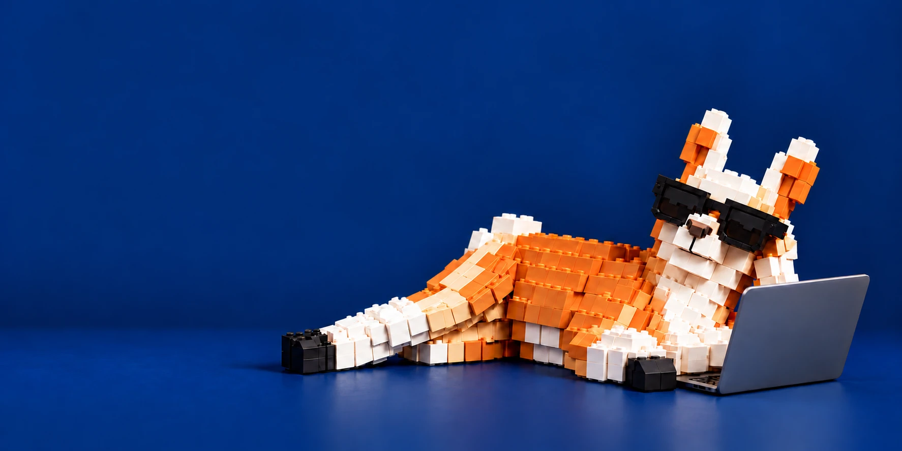 A sunglasses-wearing brick llama relaxing with a laptop on the right.
